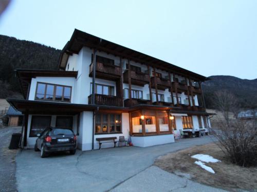 ヴァイセンゼーにあるCosy Apartment in Weissensee near Ski Liftの車が停まった建物