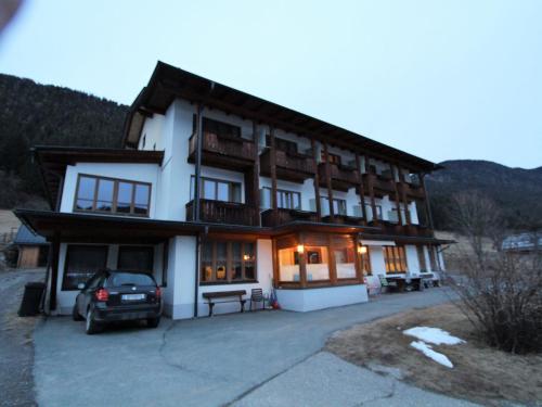 a building with a car parked in front of it at Cosy Apartment in Weissensee near Ski Lift in Weissensee