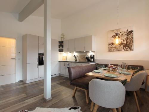 a kitchen and dining room with a table and chairs at Modern apartment with Wilder Kaiser view in Kirchdorf in Tirol