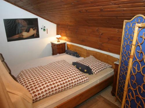 1 dormitorio con 1 cama en una habitación con paredes de madera en Apartment in Wernberg in Carinthia with pool, en Wernberg