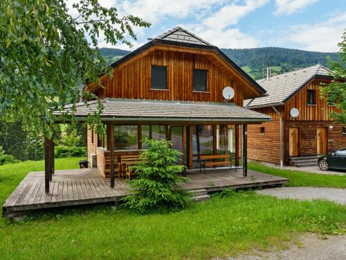 a large wooden house with a wooden deck at Chalet in Sankt Georgen near ski area in Sankt Georgen ob Murau