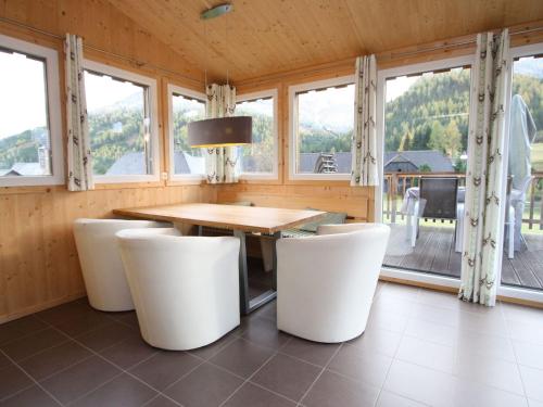 una sala da pranzo con tavolo e sedie bianche di Wooden chalet in Hohentauern with sauna a Hohentauern