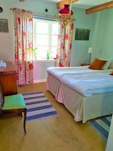 a bedroom with a bed and a window at Farmors Lycka in Kivik