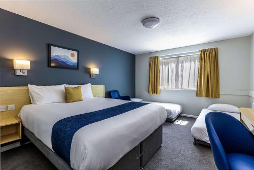 a hotel room with two beds and a desk at Days Inn Hotel Fleet in Fleet