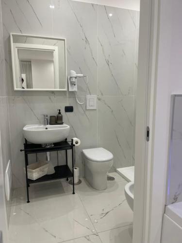 a white bathroom with a sink and a toilet at Costantino Home in Pompei