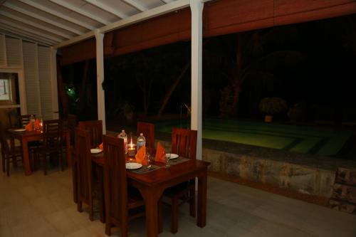 a dining room with a table and chairs on a patio at Villa A.SMS in Induruwa