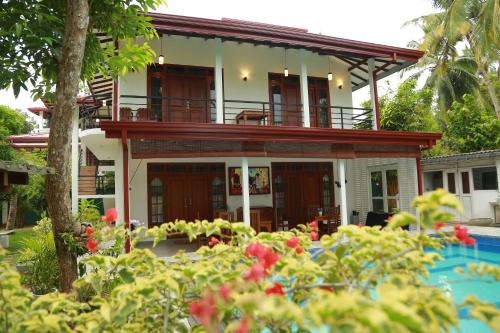 a house with a garden in front of it at Villa A.SMS in Induruwa