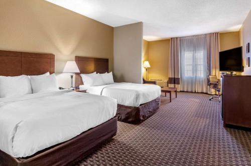 a hotel room with two beds and a television at Comfort Inn & Suites Raphine - Lexington near I-81 and I-64 in Raphine
