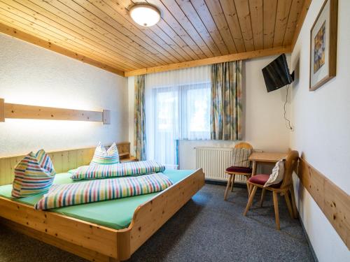 sypialnia z drewnianym łóżkiem i biurkiem w obiekcie Apartment in Saalbach-Hinterglemm near ski area w Saalbach Hinterglemm