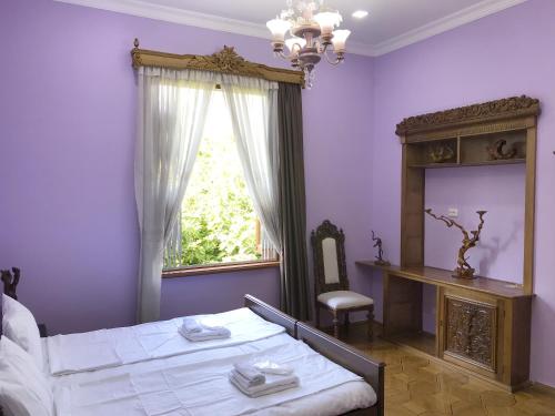 a bedroom with a bed and a window and a mirror at Wooden Museum in Kutaisi