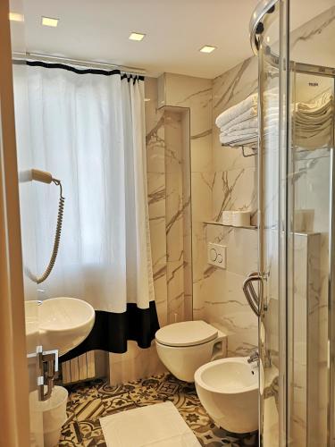 a bathroom with a sink and a toilet and a shower at Family Suite Appartments Orchidea Blu in Rimini