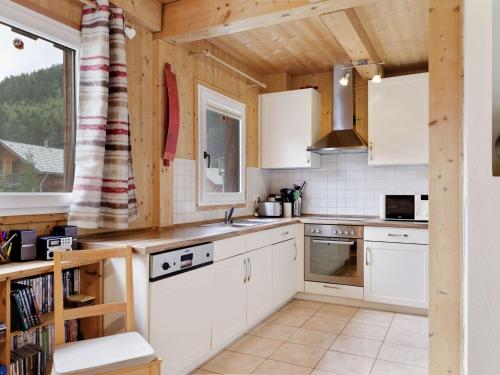 a kitchen with white cabinets and a large window at Chalet in Stadl an der Mur near the ski area in Stadl an der Mur