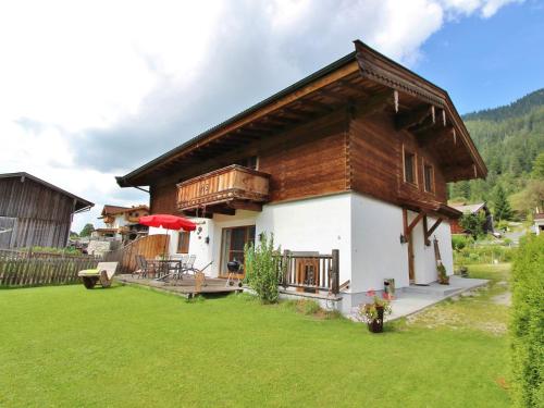 ein kleines Haus mit grünem Rasen davor in der Unterkunft Cozy feel good holiday apartment in Leogang in Leogang