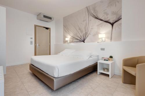 a bedroom with a bed and a painting on the wall at Hotel Nettuno in Lido di Jesolo