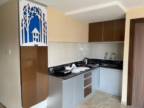 a kitchen with white cabinets and a blue sign on the wall at Dash Hotels - Affordable Luxury in Hyderabad
