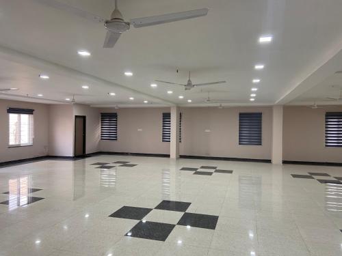 a large empty room with a checkered floor and windows at Dash Hotels - Affordable Luxury in Hyderabad