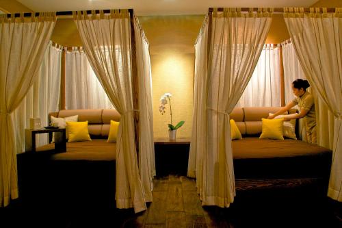 a woman sitting on a bed looking out the window at Meliá Desert Palm Member of Meliá Collection in Dubai