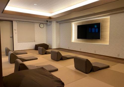 a large room with chairs and a flat screen tv at Nagoya B's Hotel in Nagoya
