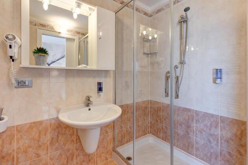 a bathroom with a sink and a shower at Hotel Nettuno in Lido di Jesolo