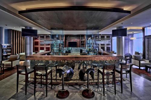 a bar in a room with chairs and tables at Meliá Desert Palm Member of Meliá Collection in Dubai