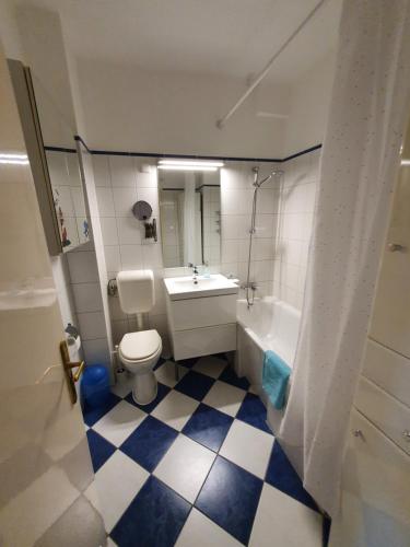 a bathroom with a toilet and a sink and a tub at M Apartments - Info Park in Budapest