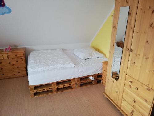 a small bedroom with a bed and a dresser at Gästehaus Querenhorst in Querenhorst