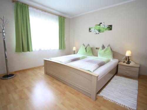 a bedroom with a bed with green curtains and a window at Apartment with terrace in Salzburg in Lungötz