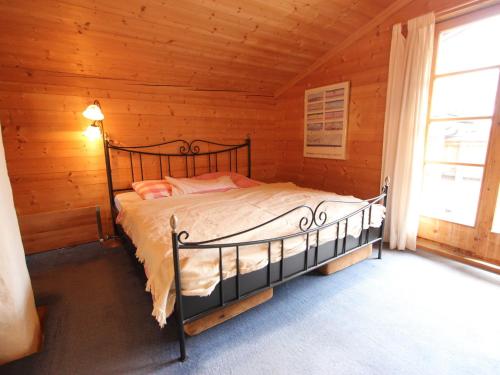 a bedroom with a bed in a log cabin at Attractive chalet right on the piste with sauna in Sankt Johann in Tirol