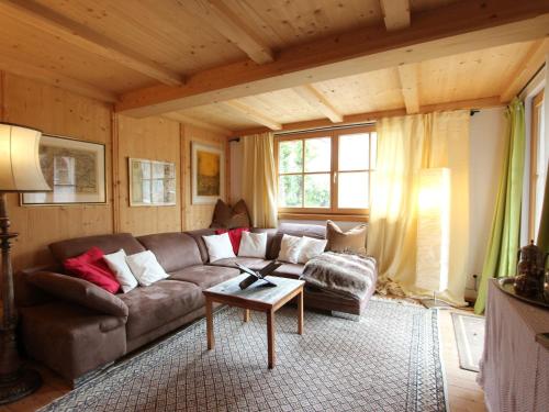 a living room with a couch and a table at Attractive chalet right on the piste with sauna in Sankt Johann in Tirol