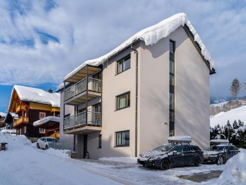 un edificio con dos coches aparcados en la nieve en Apartment in St Georgen Salzburg near ski area, en Fürstau