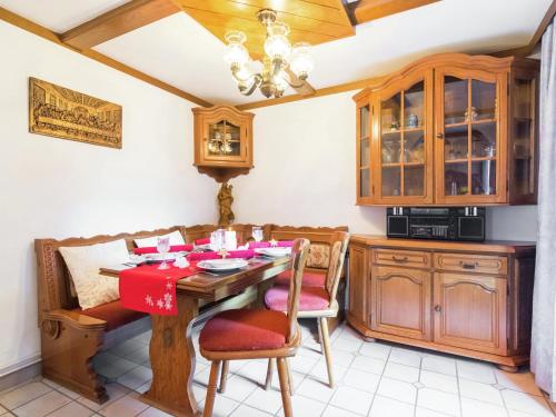 eine Küche mit einem Holztisch und einem roten Tischtuch in der Unterkunft Cottage in Rangersdorf near the ski area in Rangersdorf