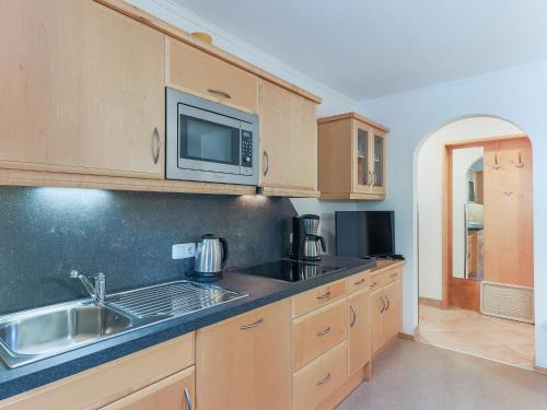 a kitchen with a sink and a microwave at Beautiful apartment in Brixen in the Thale in Brixen im Thale