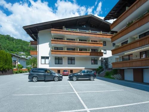 two cars parked in a parking lot in front of a building at Apartment Bergblick Anna in Kaprun with balcony in Kaprun
