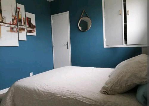1 dormitorio con 1 cama blanca y paredes azules en Appartement proche de Rennes en Vezin-le-Coquet