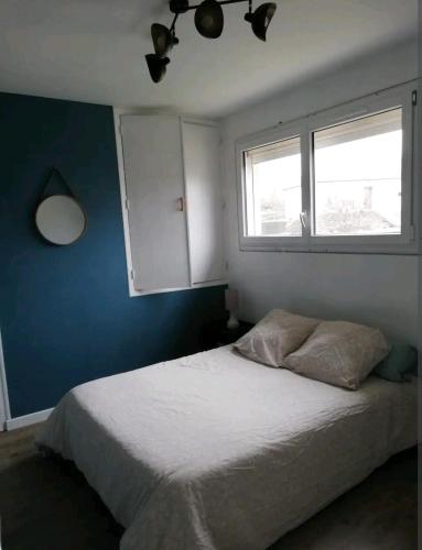 1 dormitorio con cama blanca y ventana en Appartement proche de Rennes en Vezin-le-Coquet