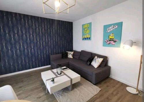 a living room with a couch and a coffee table at Appartement proche de Rennes in Vezin-le-Coquet