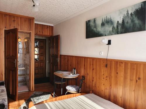 1 dormitorio con paneles de madera y mesa en una habitación en Pokoje Gościnne Angelika, en Wisła