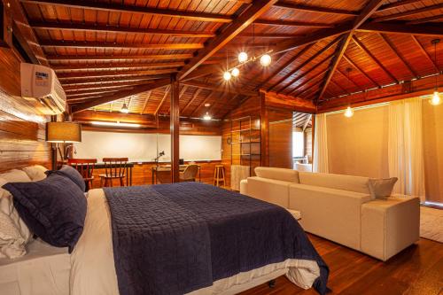 a bedroom with a bed and a couch and a table at Eco Luar Boutique Hotel in Igarassu