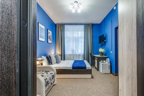 モスクワにあるDomOtel Sokolの青い壁のベッドルーム1室、ベッド1台、窓が備わります。