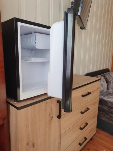 an open refrigerator on top of a wooden dresser at Pokoje Gościnne Angelika in Wisła