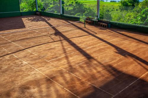 a tennis court with the shadow of a tree at Eco Luar Boutique Hotel in Igarassu