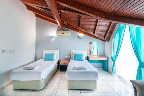 Dos camas en una habitación con cortinas azules. en Interconti Apartments, en Marmaris