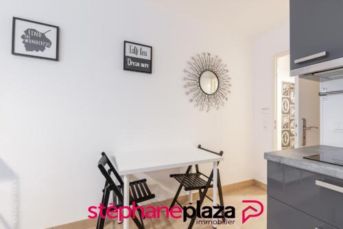 une cuisine avec une table blanche et deux chaises dans l'établissement Plaza Scandinaves 05, à Serris