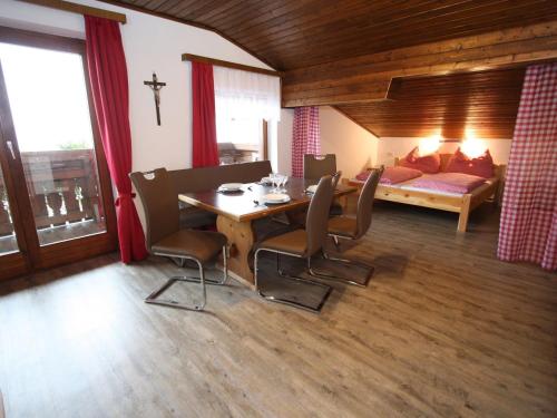 ein Wohnzimmer mit einem Tisch, Stühlen und einem Bett in der Unterkunft Snug Holiday Home in Sankt Johann im Pongau with Garden in Wagrain
