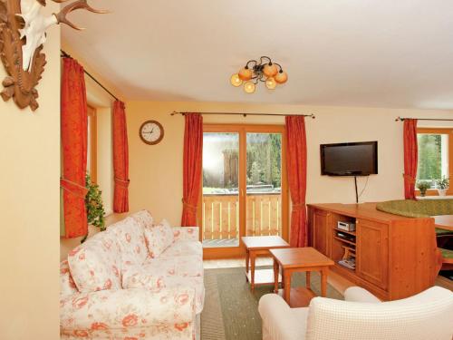 ein Wohnzimmer mit einem Sofa und einem TV in der Unterkunft Chalet apartment in ski area Saalbach-Hinterglemm in Saalbach-Hinterglemm