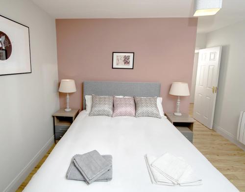 a bedroom with a large white bed with two lamps at W8 Village in Manorhamilton