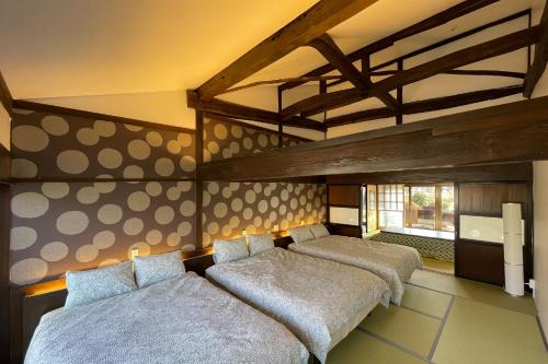 a bedroom with three beds in a room at 八ヶ岳FUJIYAMAテラス寛道 in Hokuto