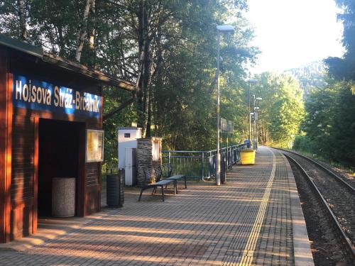 a train station with a bench next to the tracks at Hojsova stráž Brčálník Apartmán Za bukem in Frischwinkel