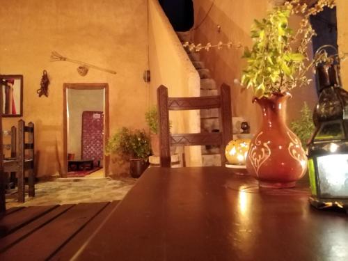 a wooden table with a vase on top of it at Maison d'hôte sirwaji in Assa