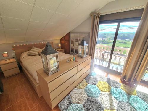 a bedroom with a large bed and a large window at La Centinela, Geoparque Costa Quebrada in Miengo